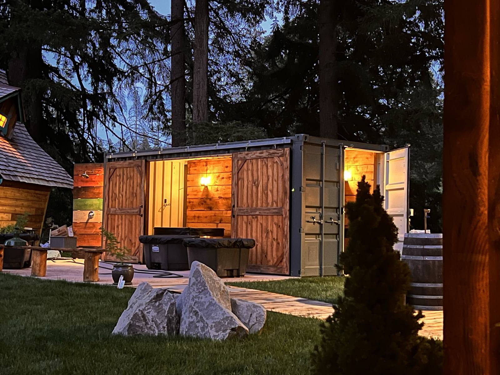 Cold plunge station with cedar barn doors open at twilight