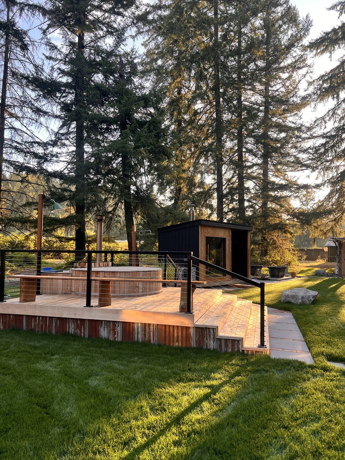 Cedar barrel cold plunge on the raised deck with the modern sauna behind